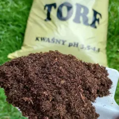 Łopata z torfem, który jest naturalnym materiałem organicznym, idealnym do zakwaszania gleby.